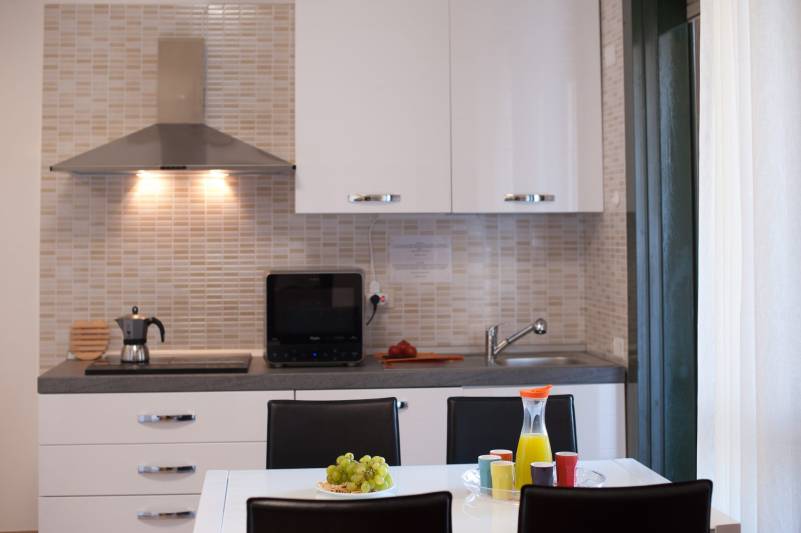 Living room with fully equipped kitchenette (including microwave oven and dishwasher). ---> Comfort holiday house with balcony in central Cagliari